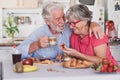 Beautiful elderly couple laughing having breakfast at home. Senior people relaxed and happy Royalty Free Stock Photo