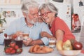 Beautiful elderly couple smiling having breakfast at home. Senior people relaxed and happy Royalty Free Stock Photo