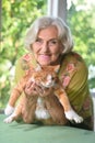 Beautiful elderly woman with a red cat at the country house Royalty Free Stock Photo