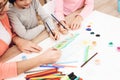 Beautiful elderly woman teaches children to draw. Little children draw. Drawing lessons.