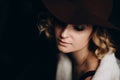 Beautiful elegant blonde girl in a hat on a dark background. Copy space for text. Soft focus Royalty Free Stock Photo