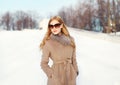 Beautiful elegant blonde woman wearing a coat jacket and sunglasses in winter Royalty Free Stock Photo