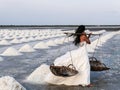 Beautiful and elegant bride with long white dress walking in salt field Royalty Free Stock Photo