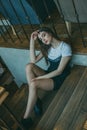 Beautiful elegant brunette girl wearing a black dress is relaxing in a street cafe. Advertising, fashion. Tinted photo Royalty Free Stock Photo