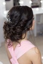 Beautiful elegant evening hairstyle on dark hair beautiful girl with an ornament from stones in her hair, hairstyle for the Royalty Free Stock Photo