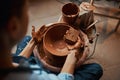 Beautiful elegant female arms with tool modeling non painted tableware in pottery workshop