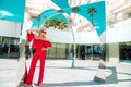 Beautiful elegant female fashion model in red dress standing in front of the luxury hotels and boutiques Royalty Free Stock Photo