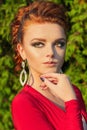 Beautiful elegant girl with beautiful makeup and hair in a red evening dress in the Park Royalty Free Stock Photo