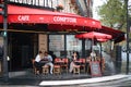 Beautiful elegant girl in Paris sits in a Parisian cafe and drinks coffee with a croissant