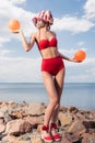 beautiful elegant girl in red bikini and silk scarf posing with balls