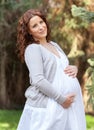 Beautiful elegant pregnant woman holding belly