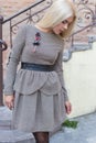 Beautiful elegant slim blonde girl in elegant dress with brooch up the stairs in the city Royalty Free Stock Photo