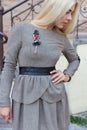 Beautiful elegant slim blonde girl in elegant dress with brooch up the stairs in the city Royalty Free Stock Photo