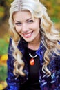 Beautiful elegant smiling woman standing in a park in autumn