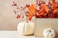 Beautiful elegant Thanksgiving autumn decorative composition with white pumpkins orange maple leaves branches with red berries.