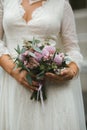 Beautiful elegant wedding bouquet of pink flowers, roses, chrysanthemums and eucalyptus in the hands of the bride in a vintage lac Royalty Free Stock Photo