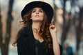 Beautiful elegant woman in black hat outdoor. Fashion look, euro