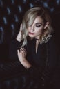 Beautiful elegant woman blonde in a black dress with feathers in retro style 1920 fashion. Soft selective focus Royalty Free Stock Photo