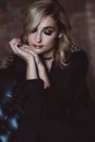 Beautiful elegant woman blonde in a black dress with feathers in retro style 1920 fashion. Soft selective focus Royalty Free Stock Photo