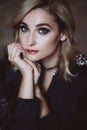 Beautiful elegant woman blonde in a black dress with feathers in retro style 1920 fashion. Soft selective focus Royalty Free Stock Photo