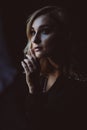 Beautiful elegant woman blonde in a black dress with feathers in retro style 1920 fashion. Soft selective focus Royalty Free Stock Photo