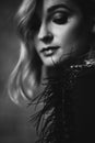 Beautiful elegant woman blonde in a black dress with feathers in retro style 1920 fashion. Soft selective focus. Black and white Royalty Free Stock Photo