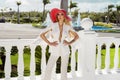 Beautiful, elegant woman in a white suit posing on the background of the caribbean palms