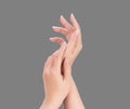 Beautiful and elegant woman hands isolated on standard neutral gray background, concept of applying moisturizing cream and body