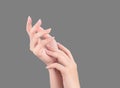 Beautiful and elegant woman hands isolated on standard neutral gray background, concept of applying moisturizing cream and body