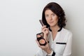 Beautiful elegant woman with make-up demonstrates the decorative cosmetic products in jars for applying makeup on a white backgrou