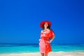 Beautiful elegant woman in red hat enjoying on exotic sea, tropical beach. summer outdoor portrait. Attractive girl model. Royalty Free Stock Photo