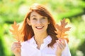 Beautiful elegant woman standing in a park in autumn. Beautiful girl walking outdoors in autumn. Smiling girl collects