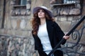 Beautiful elegant woman in stylish trendy black coat and hat ove