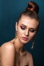 Beautiful elegant young girl with bright colorful trendy smoky eyes, bun hairstyle and trendy gold earrings Royalty Free Stock Photo