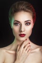 Beautiful elegant young model with red lips and color evening make-up.Woman Face on dark background.Picture taken in the studio Royalty Free Stock Photo