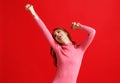 Beautiful emotional girl in pink dress on red background