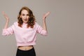 A beautiful emotional girl raises her hands up from happiness and what she sees on a gray background Royalty Free Stock Photo