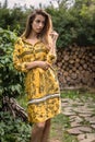 Beautiful emotional outdoor portrait of young woman in yellow dress.