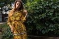 Beautiful emotional outdoor portrait of young woman in yellow dress.