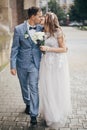 Beautiful emotional wedding couple kissing and walking in european city. Provence wedding. Stylish happy bride and groom walking Royalty Free Stock Photo