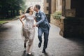 Beautiful emotional wedding couple smiling and kissing in rain in european city. Provence wedding. Stylish happy bride and groom Royalty Free Stock Photo