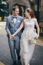 Beautiful emotional wedding couple smiling and walking in european city. Provence wedding. Stylish happy bride and groom walking Royalty Free Stock Photo