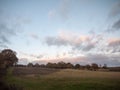 Beautiful empty open country farm field space tree line clouds a Royalty Free Stock Photo