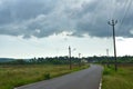 Beautiful Empty road in Autumn season with green fields and cloudy sky in Goa Royalty Free Stock Photo