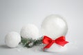 Beautiful empty snow globe, Christmas balls and fir branches on light grey background Royalty Free Stock Photo