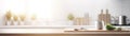 Beautiful empty white wooden table top with the background blurred defocused of a white modern kitchen interior with daylight Royalty Free Stock Photo