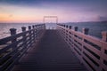Beautiful empty wooden footbridge pier in koper in colorful purple sunset, slovenia Royalty Free Stock Photo