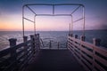 Beautiful empty wooden footbridge pier in koper in colorful purple sunset, slovenia Royalty Free Stock Photo