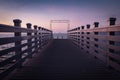 Beautiful empty wooden footbridge pier in koper in colorful purple sunset, slovenia Royalty Free Stock Photo