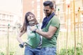 Beautiful engaged couple watering plants in the garden